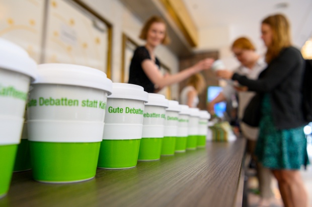 Registrierung bei der Nah Dran Tagung 2019 mit Kaffeebecher: "Gute Debatten statt Kaffeesatzleserei"